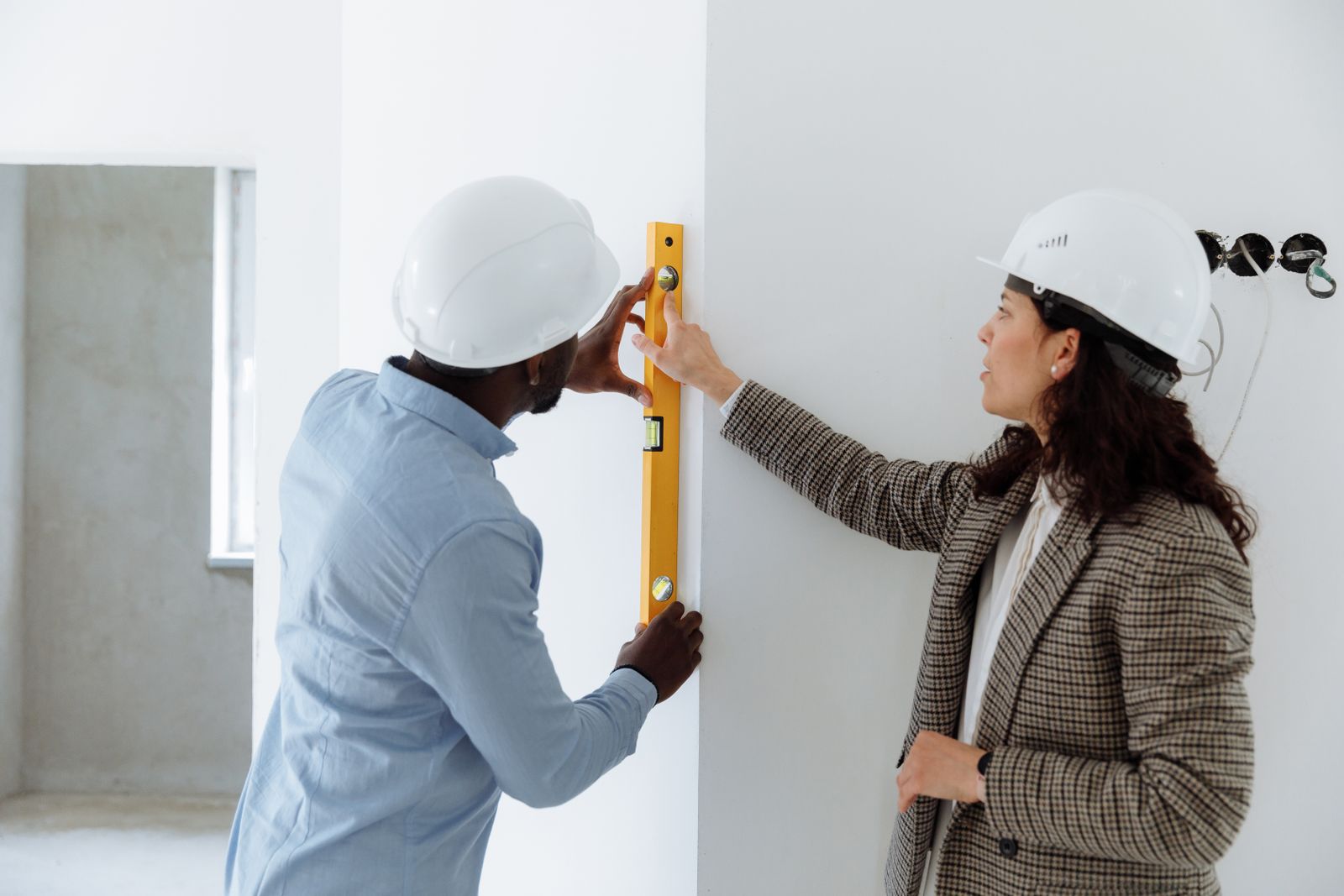 Contractors checking wall alignment during envelope work